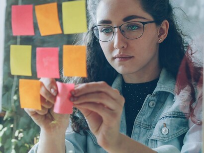 A young woman organizing ideas on a board, reflecting meaningful youth participation in shaping responses to the climate crisis