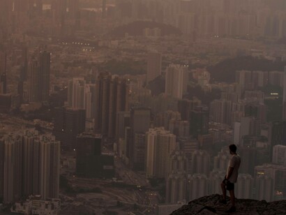 Contemplating on the doing while on a hill overlooking the bustling skyscraper city of Honk Kong