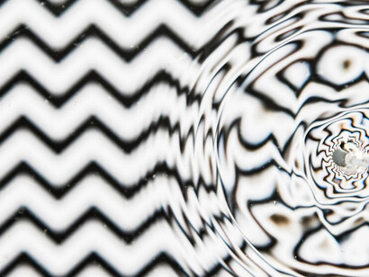 Large water droplet on a black and white pool surface