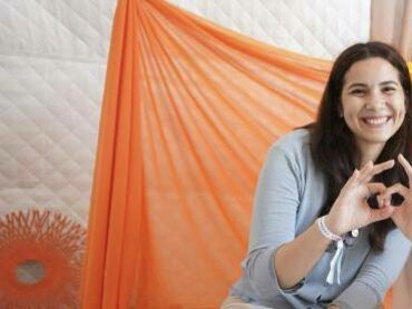 Woman smiles and makes a circle motion with her hand