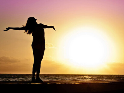 Silueta de una mujer junto al mar durante la Golden Hour