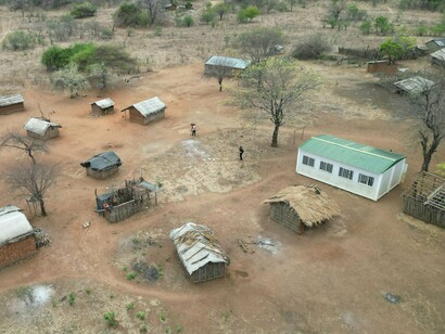 Habitações simples cercadas por um ambiente árido revelam os desafios da adaptação. A falta de infraestrutura limita a resposta às mudanças climáticas