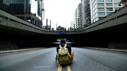 Homem fotografa placa que dá nome a um túnel. Será que alguma pessoa tem mérito suficiente para ser nome de rua? Muitos feitos heroicos ou significativos se dissipam com o tempo, ficam ultrapassados e, até mesmo, o que foi muito importante e valioso numa ocasião, em outra época pode ser irrelevante
