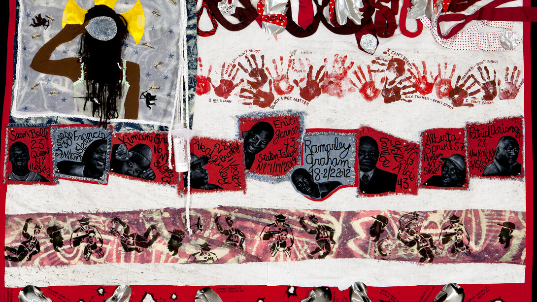american Juju for the Tapestry of Truth, 2015, Mixed media on a textile impregnated on the spot in Staten Island where Eric Garner died while being placed under arrest. Created by artists from the Harlem Needle Arts cultural arts institute: Sahara Briscoe, Laura R. Gadson, and Jerry Gant, under the direction of Michelle Bishop, 66 x 98 inches