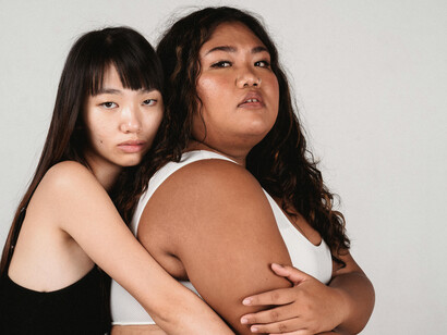 Asian homosexual couple embracing and hugging each other against a gray background