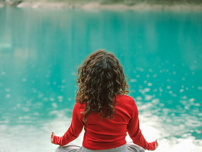 Praticante de yoga senta sob seus ísquios em momento de meditação guiada. Textos antigos como o Bhagavad Gita oferecem conselhos atemporais sobre enfrentar batalhas internas