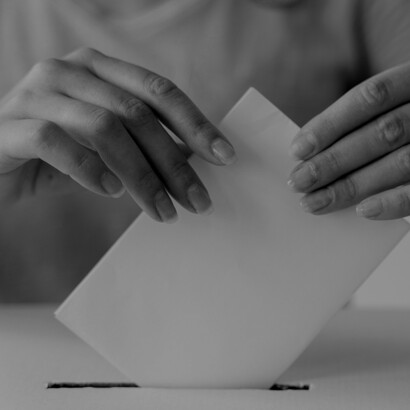 A close-up of hands submitting a ballot captures the essence of democracy as Chile prepares for a decisive electoral moment in 2025