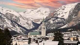 Cortina d'Ampezzo, Veneto, Italia. Cortina deve gran parte della sua fama alla bellezza naturale delle Dolomiti circostanti. Le maestose vette rocciose, i boschi di abeti e i prati alpini creano uno scenario spettacolare che cambia con le stagioni. Durante l'inverno, le montagne sono coperte da un candido manto di neve, offrendo uno spettacolo mozzafiato che incanta gli occhi di chiunque