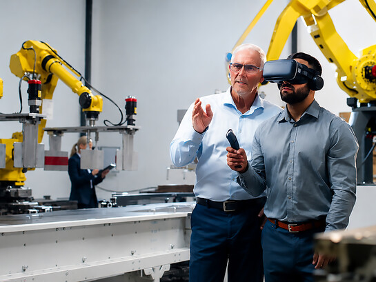 Business professionals using virtual reality headsets in an advanced robotics warehouse, conducting quality control inspections and evaluating next-generation automation systems in a smart factory environment