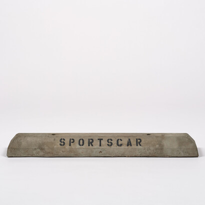 Jason Rhoades,
Sportscar Concrete Car Stop (detail),
1993.
Concrete car stop with text.
12.1 x 120 x 18.4 cm / 4 3/4 x 47 1/4 x 7 1/4 in.
Photo: Keith Lubow© The Estate of Jason Rhoades. Courtesy of the Estate of Jason Rhoades and Hauser & Wirth