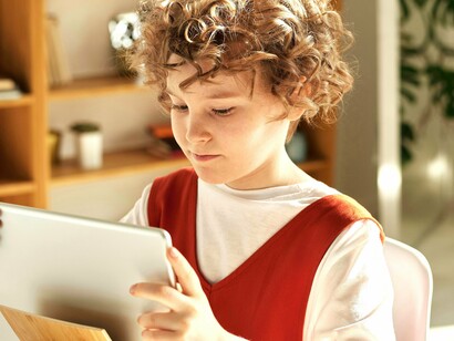 Garoto brinca com game educativo. Em vez de se limitarem a aprender um conceito apenas através de leitura ou instrução direta, os jogos permitem que as crianças apliquem o que aprenderam de forma prática, em um contexto interativo
