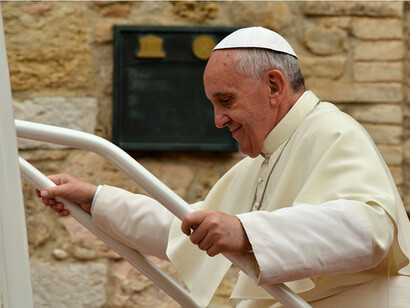 Papst Franziskus, lächelnd, eine Leiter klettern