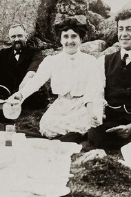 An old photo of friends at a picnic having tea