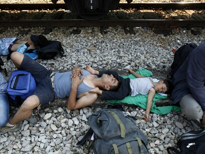 Migrantes sirios junto a la vía de un tren