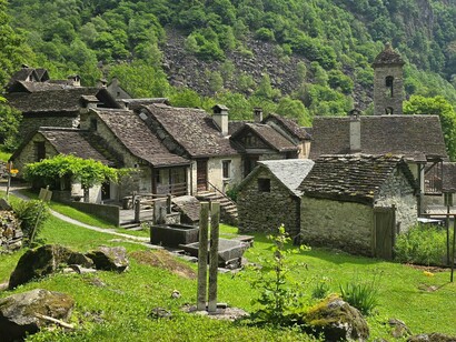 A stone village within a lush mountain area, representing architecture shaped by local materials, climate and regional identity