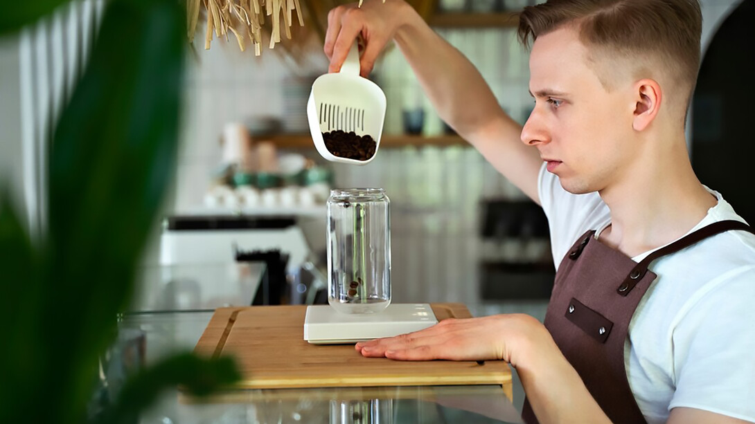 A barista preparing a beverage and brewing coffee with precision