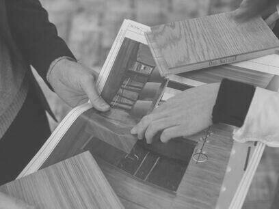 Dettaglio delle mani di un architetto che sceglie il tipo di legno da utilizzare per la costruzione di una libreria