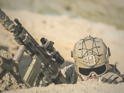 The soldier conceals himself among the sand dunes