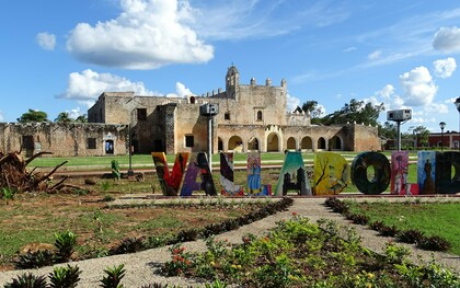 A colorful sign stands prominently in front of the historic Convento de San Bernardino de Siena, showcasing the picturesque town that captivates visitors with its riotously colorful streets and rich history