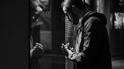 Homem se observa em reflexo