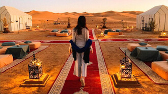 Mujer frente a un campamento de lujo en el Desierto del Sahara