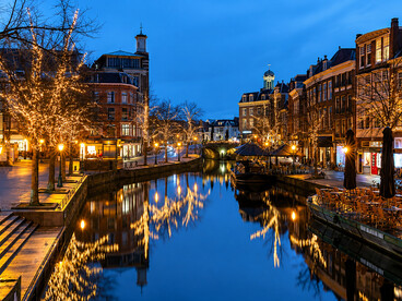 Christmas lights glow along a peaceful canal in Leiden, Netherlands