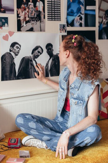 Teenage girl on her bed, surrounded by cassette tapes and lost in thought