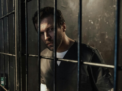 Man gazing outside from behind prison bars