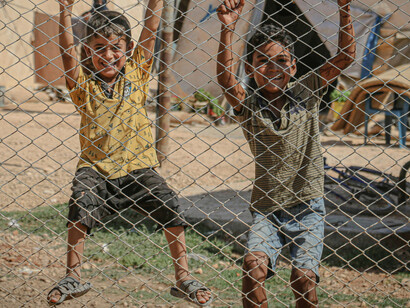 The natural energy and closeness of the kids against the barrier in front of them
