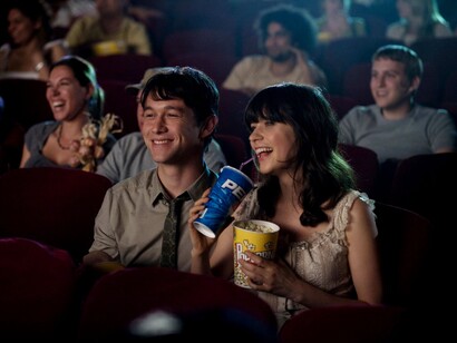 Una chica disfrutando de unas palomitas y un refresco en una sala de cine