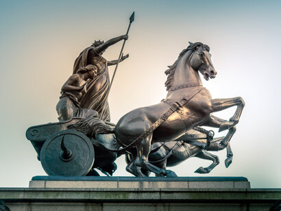 Bronze sculpture of god standing with spear in carriage with horses