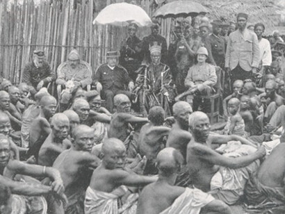 Photograph of the ceremony which formally incorporated the Ewi of Ados kingdom in the British Lagos Protectorate. Ado was one of several Yoruba kingdoms situated in what is now Nigeria, used as part of an online exhibition about the "Scramble for Africa"