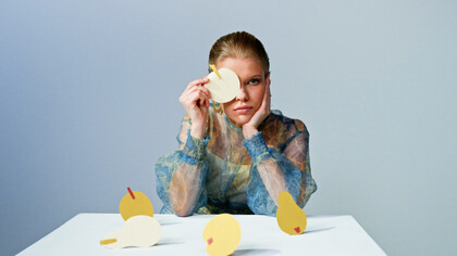 The model gazes into the lens, embodying the struggle between creativity and conformity in a rapidly changing world