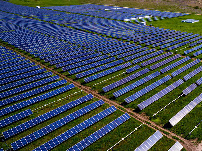 Solar panels in a field. Since large solar arrays produce low-energy-density, they require massive amounts of acreage to supply industries (i.e., data centers) with sufficient power