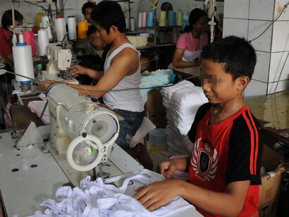 In Jakarta, Indonesia, child laborers work in a small garment factory, handling tasks like sewing and packaging