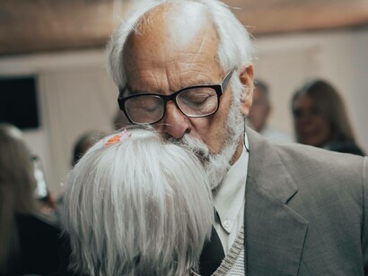 An elderly couple closing their eyes as they dance and ignore their ageing