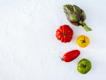 Una alcachofa y cuatro tomates de distinta variedad. La alimentación consciente es clave para nuestra salud