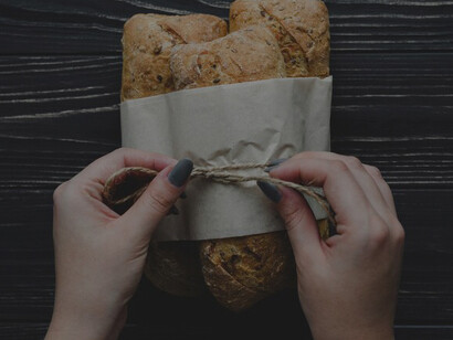 Close-up of hands tying a bunch of freshly baked buns, a delightful treat for any occasion