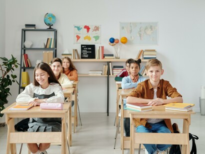Happy students in a classroom. What if noise inside the classroom is perceived as positive and healthy? 