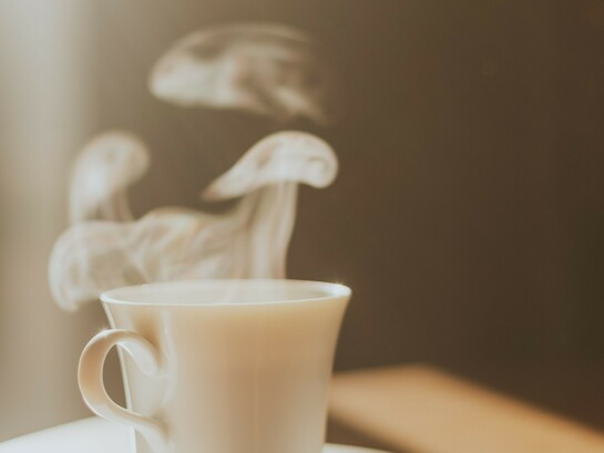 Vapeur s'échappant d'un café servi dans une tasse en porcelaine, peut-être celle d'un hôtel de luxe