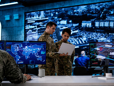 Military personnel using advanced technology to analyze and monitor data in a command center