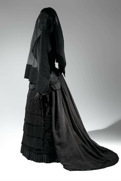 Mourning Ensemble, 1870-1872, Black silk crape, black mousseline. The Metropolitan Museum of Art, Brooklyn Museum Costume Collection at The Metropolitan Museum of Art, Gift of the Brooklyn Museum, 2009; Gift of Martha Woodward Weber, 1930 (2009.300.633a, b), Veil, ca. 1875, Black silk crape. The Metropolitan Museum of Art, Gift of Roi White, 1984 (1984.285.1). Photo: © The Metropolitan Museum of Art, by Karin L. Willis