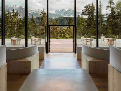 Area comune e terrazza esterna con vista sui pini e le montagne all'orizzonte, hotel Forestis, Bressanone, Alto Adige, Italia