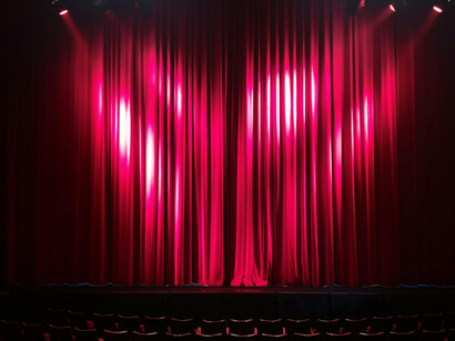 Rows of red chairs and matching curtains create a classic theatre salon