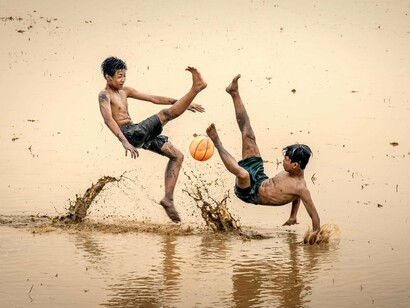 Garotos brincam em água acumulada da chuva. Minha infância foi muito boa, tive oportunidade de ser criança no mais alto grau, brinquei a valer, aprontei muitas travessuras, como minha mãe dizia: “você não sabia obedecer”, e era bom não saber, me dava liberdade de fazer o que viesse na telha, mas também tinha as consequências e, pior do que as chineladas, que eu tirava de letra, era o castigo, coisa chata ficar na sala sentado no sofá...