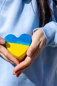 Closeup heart in the color of the flag of ukraine in female hands
