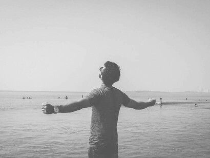 A man with arms stretched out while looking at the sky as a sign of liberation