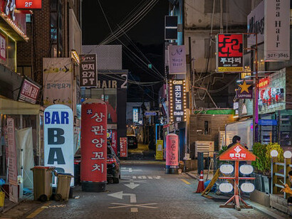 As night falls in Seoul, South Korea, streets transform into a dynamic, bustling scene where modern architecture and traditional culture coexist, offering a glimpse into the city's unique energy