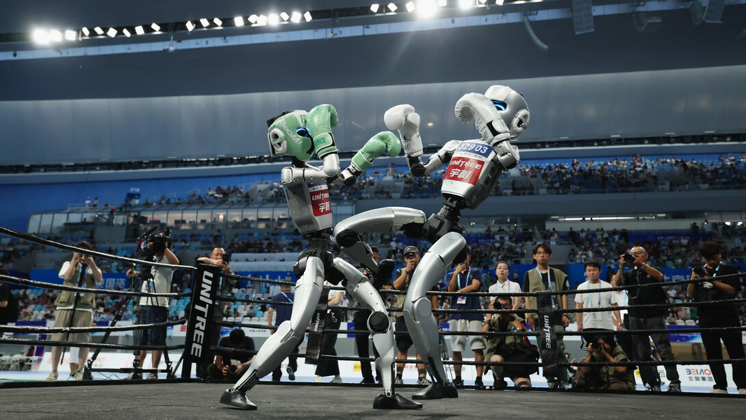 Robôs humanoides disputam uma luta de kickboxing durante os Jogos Mundiais de Robôs Humanoides, em Pequim, em agosto de 2025. O avanço da inteligência artificial e da robótica se torna também um campo de disputa sobre os modelos de sociedade e de poder que poderão moldar o futuro