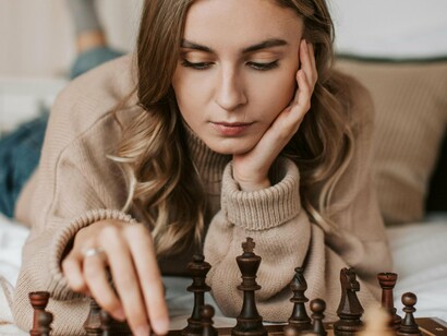 Une femme réfléchit attentivement à son prochain coup dans une partie d'échecs